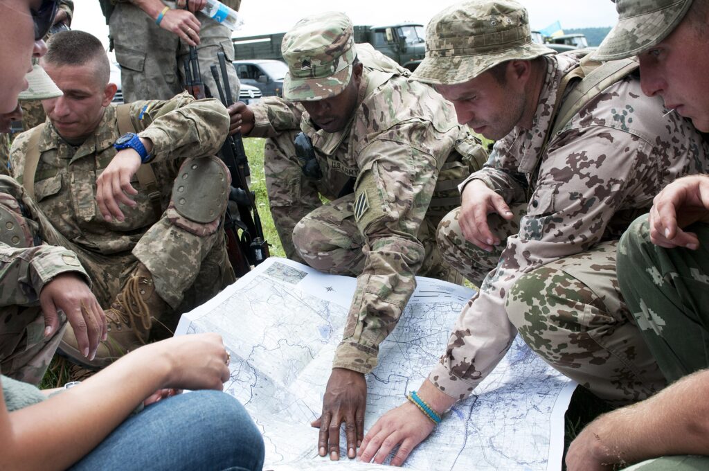 PD © Photo by Staff Sgt. Elizabeth Tarr (Army Sgt. Robert Taylor, Bravo Troop, 6-8 Cav. Reg., 2nd IBCT, 3rd ID, and Ukrainian soldiers study a map before land navigation training at the International Peacekeeping and Security Center)