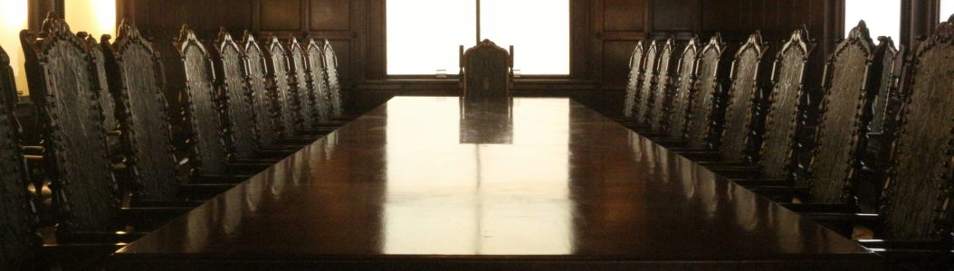 © André Ravazzi/Unsplash(Rectangular brown wooden table with chairs. Symbolising a potential European Security Council meeting.)